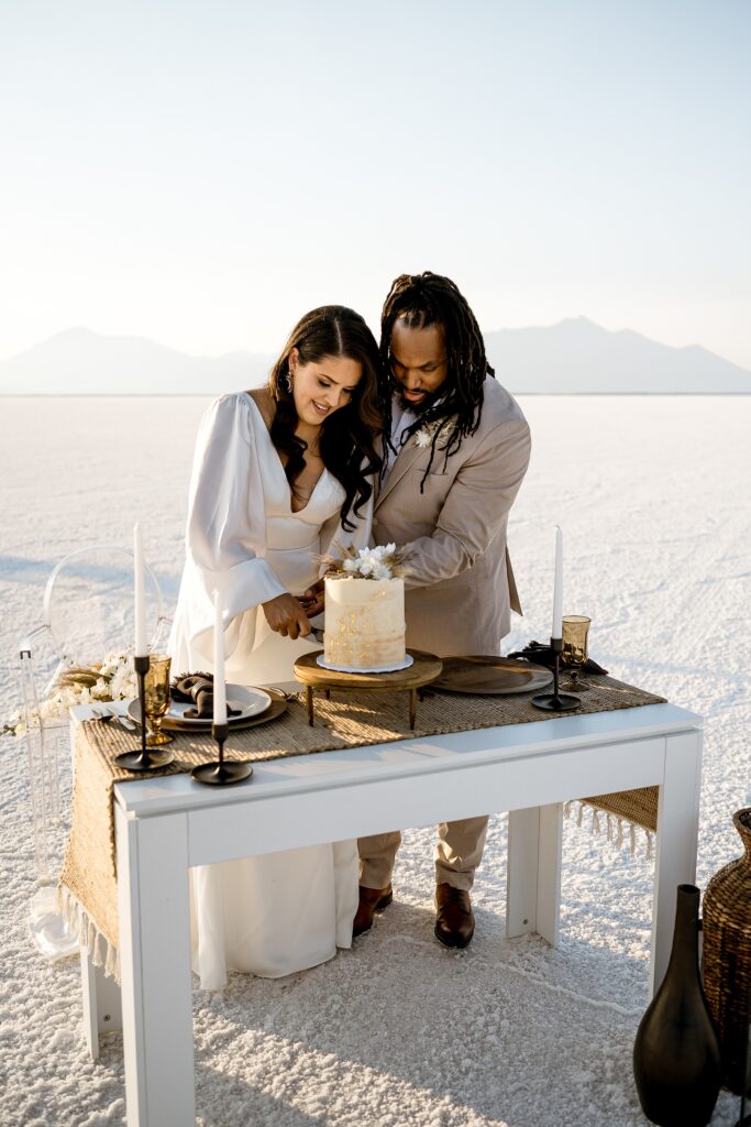 Utah elopement photographer captures bride and groom cutting cake as newly married couple
