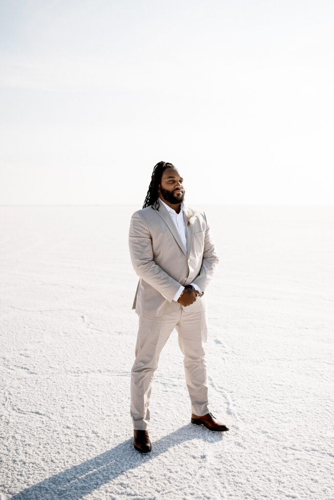 Utah elopement photographer captures groom standing in tan suit waiting for his bride