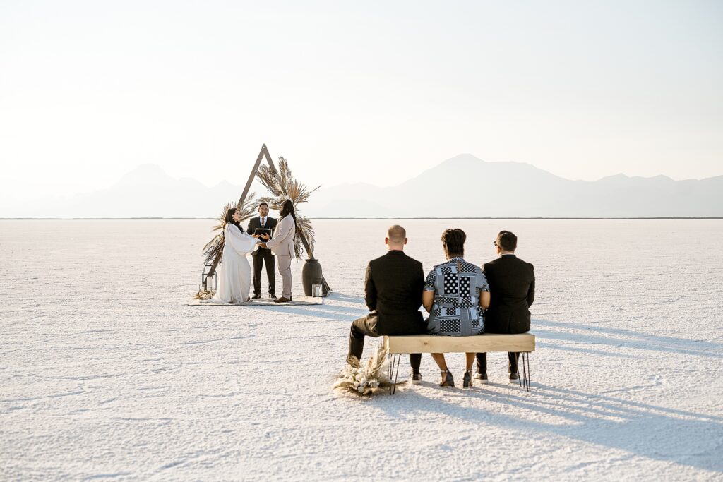 Utah elopement photographer captures guests sitting and listening during Salt Flats wedding
