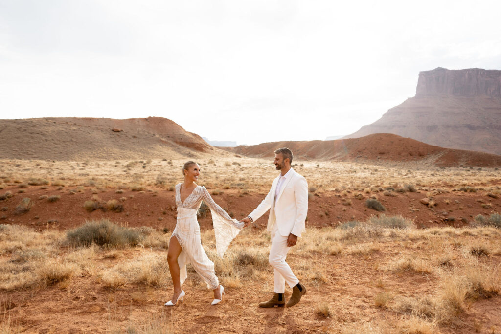 Moab elopement photographer captures bride leading groom through Moab