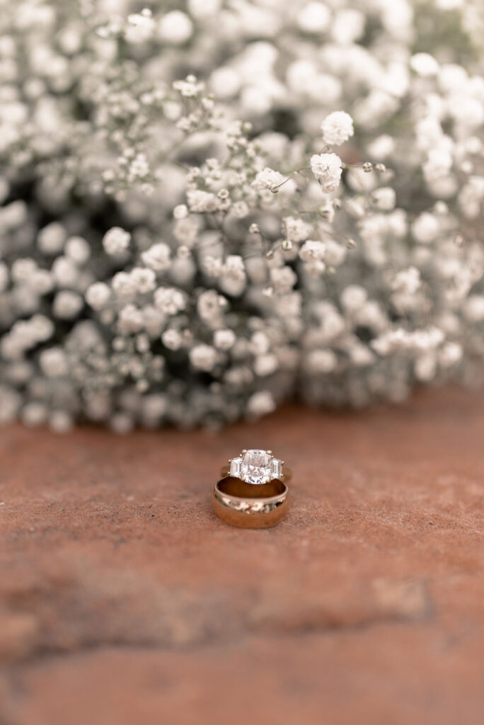 Moab elopement photographer captures engagement ring and wedding band in front of baby's breath