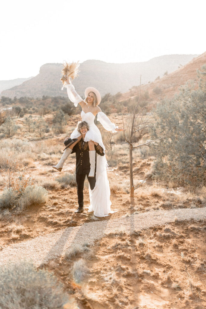 Utah elopement photographer captures bride on groom's shoulders after Kanab Utah elopement