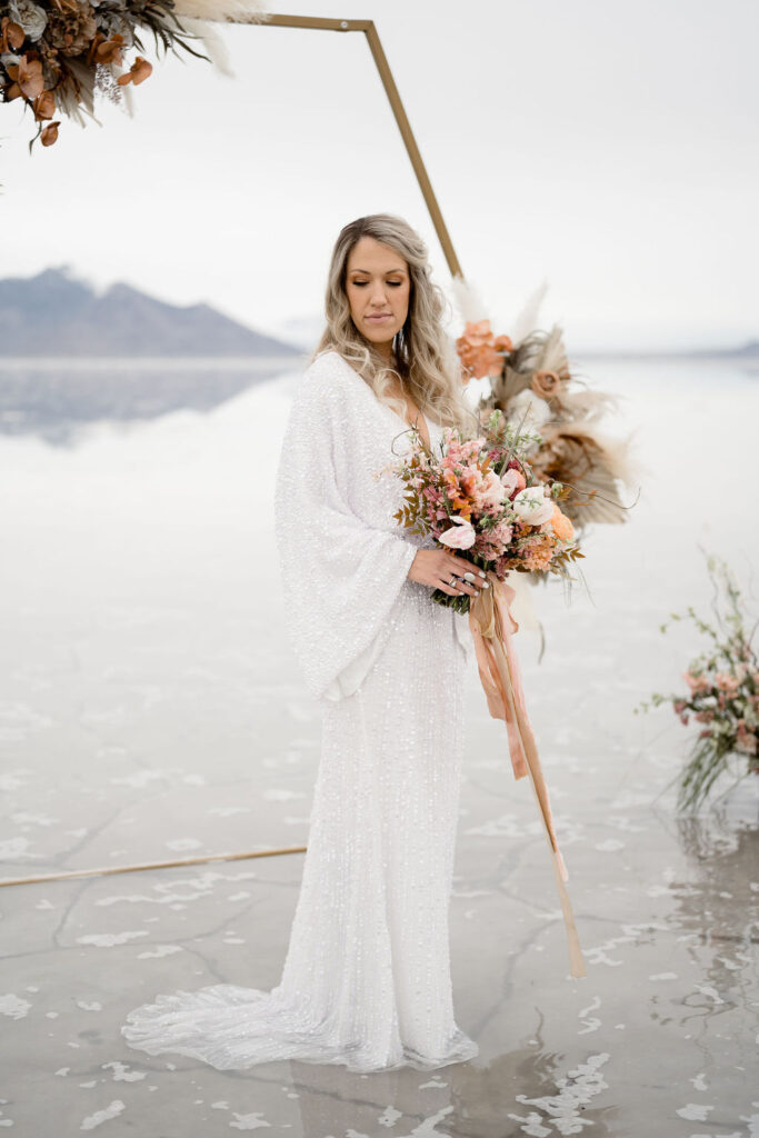 Utah elopement photographer captures bride wearing sparkly sequined dress while holding boho inspired bridal bouquet