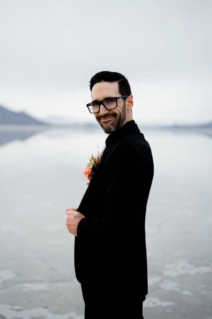 Utah elopement photographer captures groom wearing black suit smiling at camera
