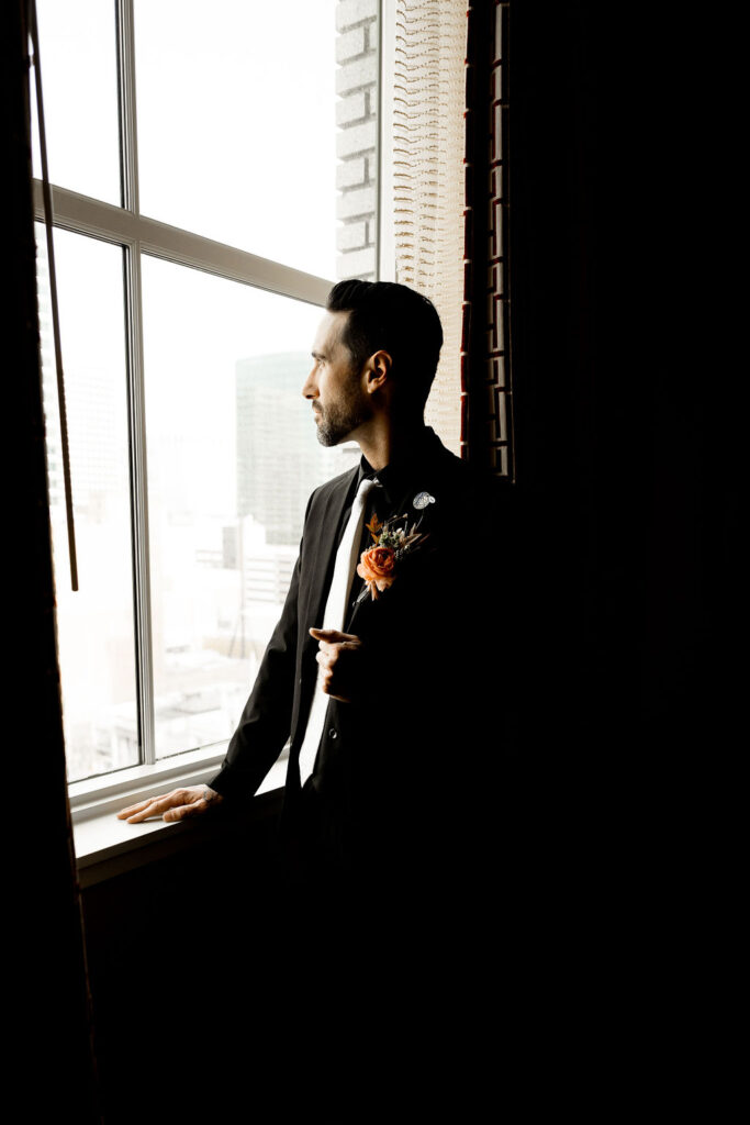 Utah elopement photographer captures groom looking out the window