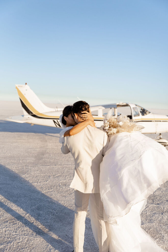 Utah elopement photographer captures bride and groom walking off to the airplane