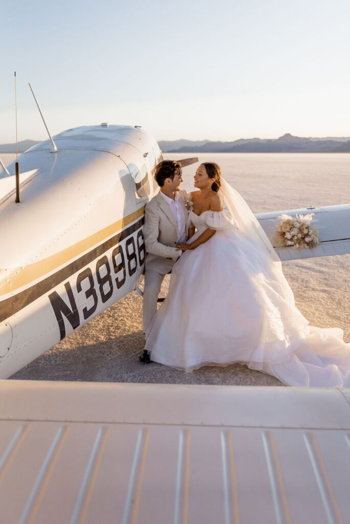 Utah elopement photographer captures bride and groom hugging on airplane