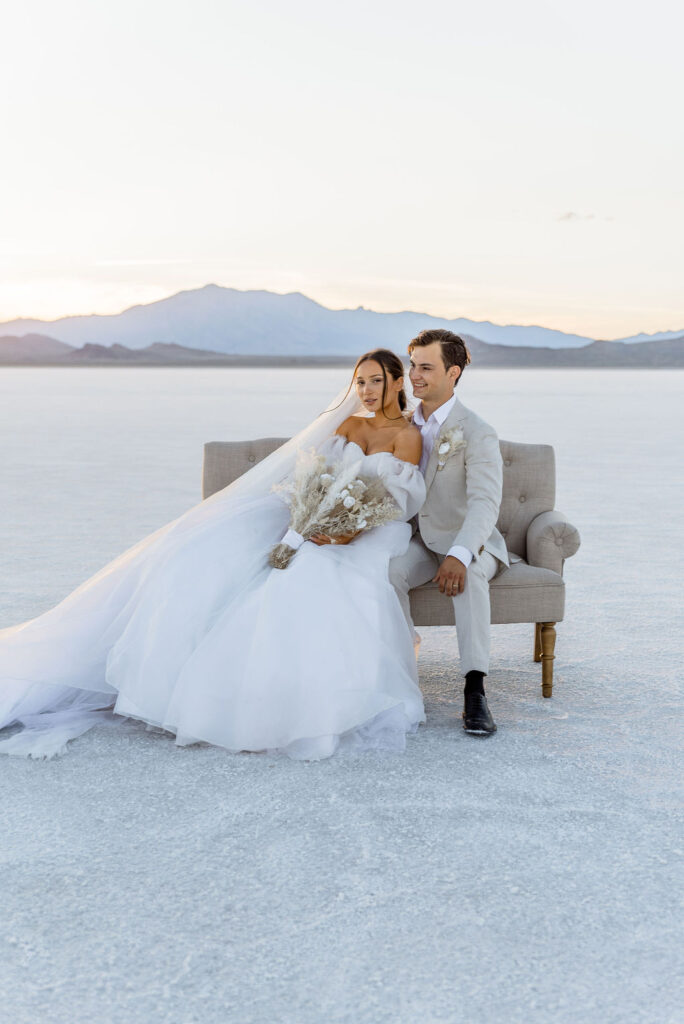 Utah elopement photographer captures bridal couple sitting on couch during sunset portraits
