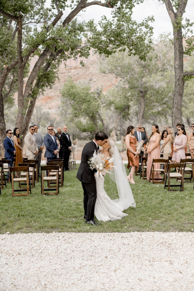 Utah elopement photographer captures bride and groom exiting wedding ceremony with a kiss