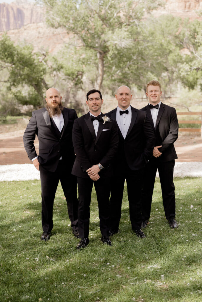 Utah elopement photographer captures groom with groomsmen wearing tuxedos