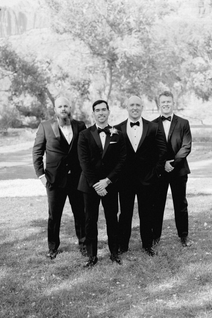 Utah elopement photographer captures groom with groomsmen in black tie attire