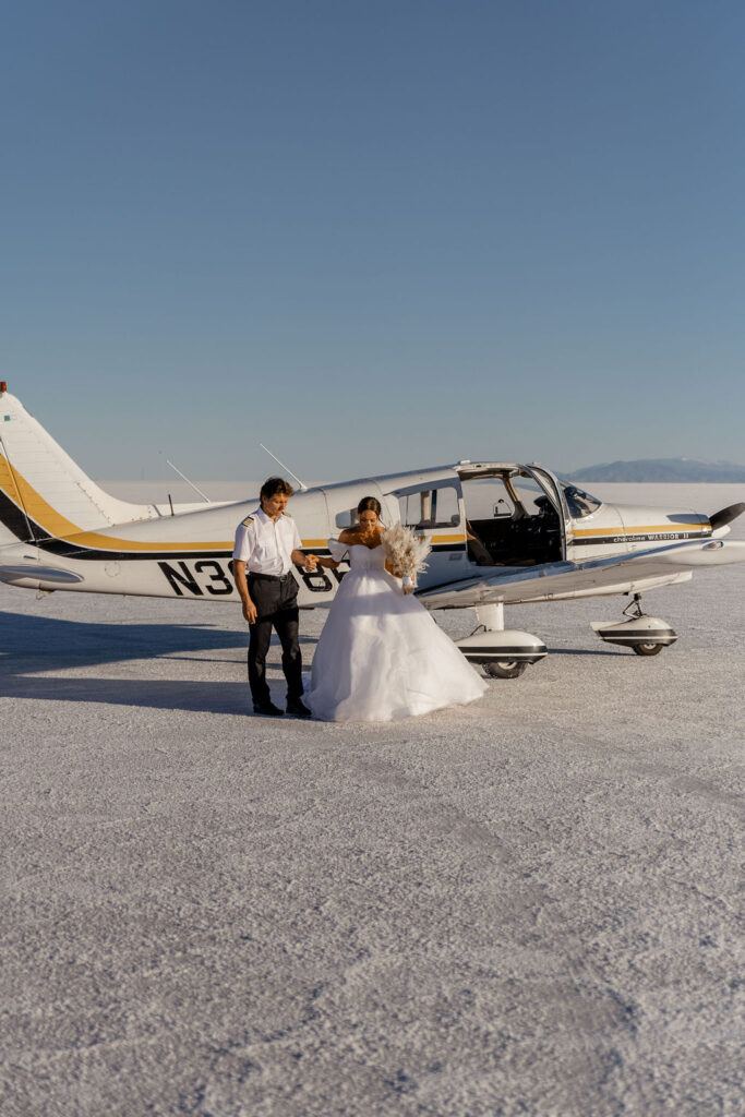 Utah elopement photographer captures bride's father helping her out of airplane to walk down the aisle