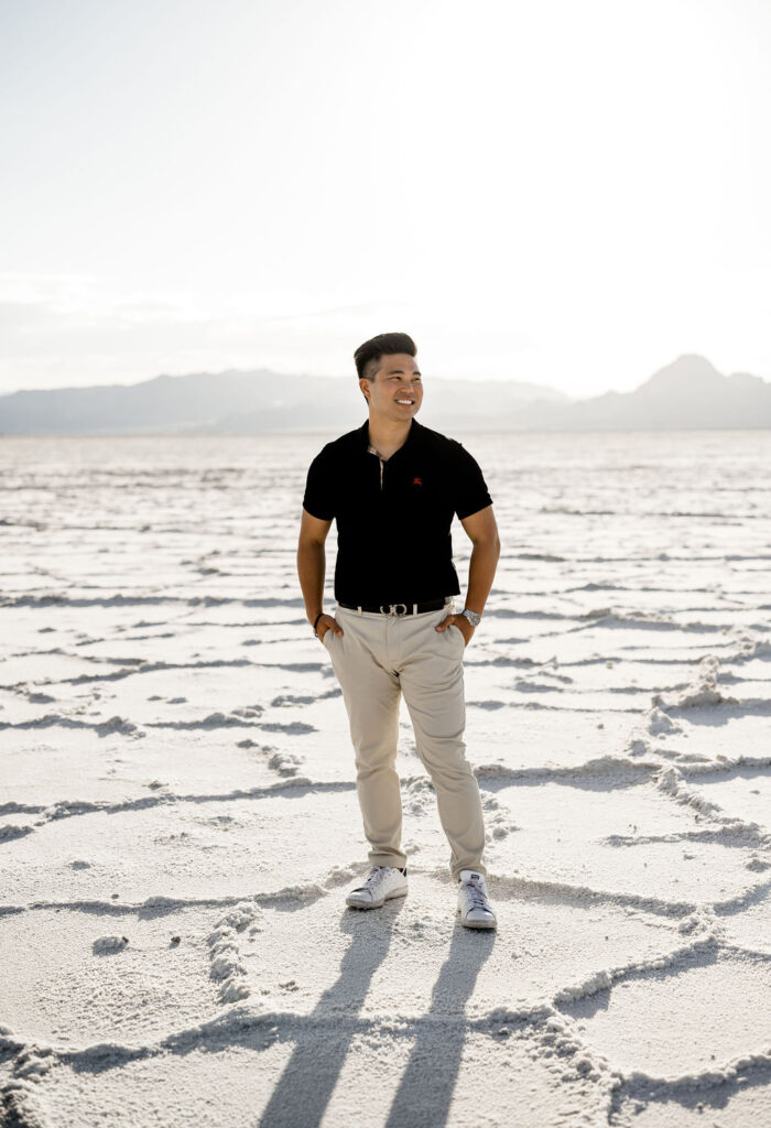 Utah elopement photographer captures man wearing black polo shirt and khakis during classic salt flats engagemnets