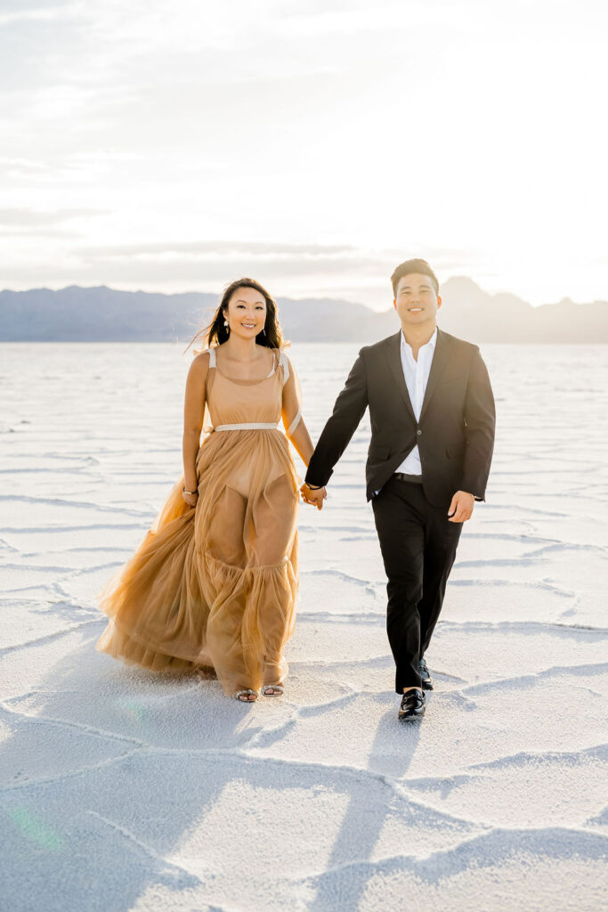 Utah elopement photographer captures man and woman walking hand in hand during Salt Flats