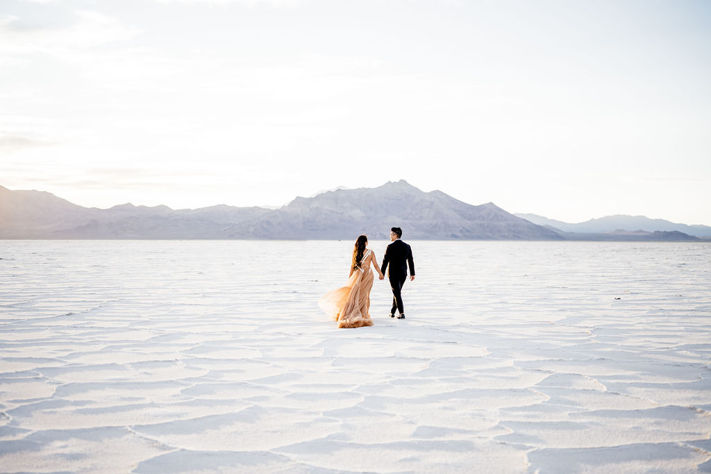 Utah elopement photographer captures couple walking during classic salt flats engagements