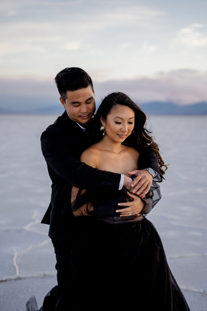 Utah elopement photographer captures man hugging woman during classic salt flats engagements