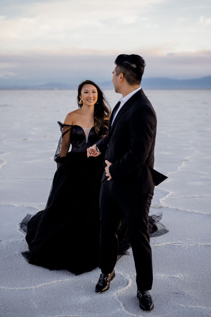 Utah elopement photographer captures man holding womans hand and looking back at her