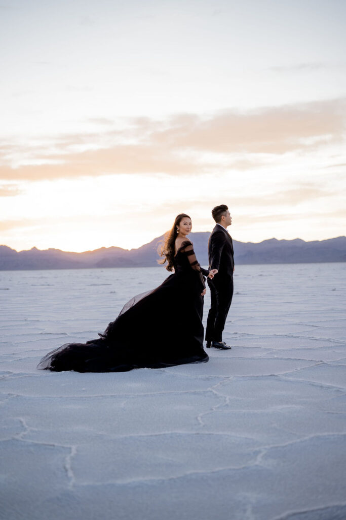 Utah elopement photographer captures couple walking away during sunset at Salt Flats