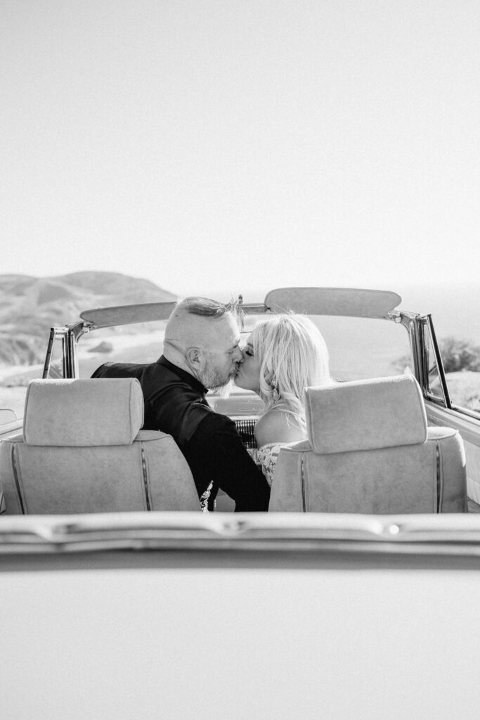 Big Sur elopement photographer captures couple driving away in black and white portrait