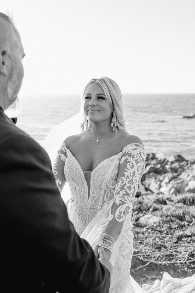 big sur elopement photographer captures black and white portrait of bride looking at groom during wedding ceremony