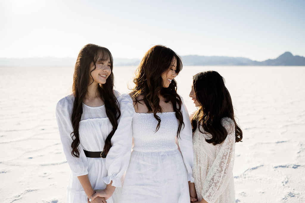 mother and daughters at the salt flats in white dresses