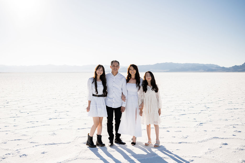family photos at the salt flats in white at sunset