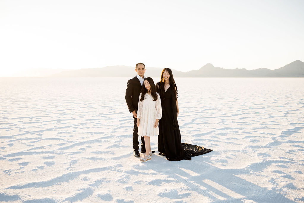 father and daughters at the salt flats at sunset in dresses and suit at sunset