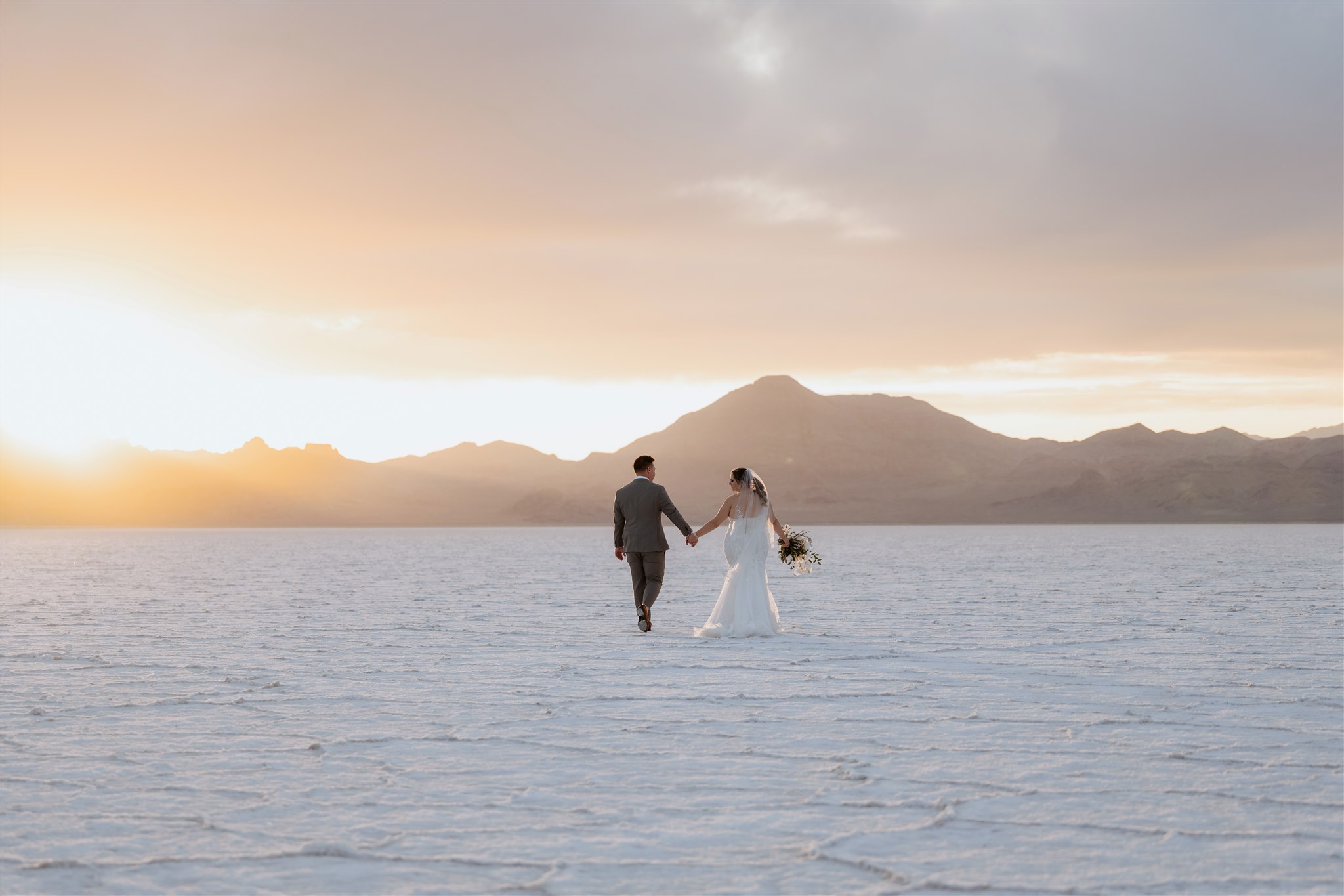 Bride and groom holding hands at their Bonneville Salt Flats elopement in Utah
