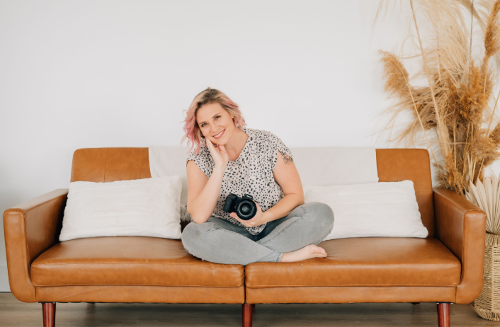 Coley Cook, a wedding photographer in Utah, is posing with her camera.
