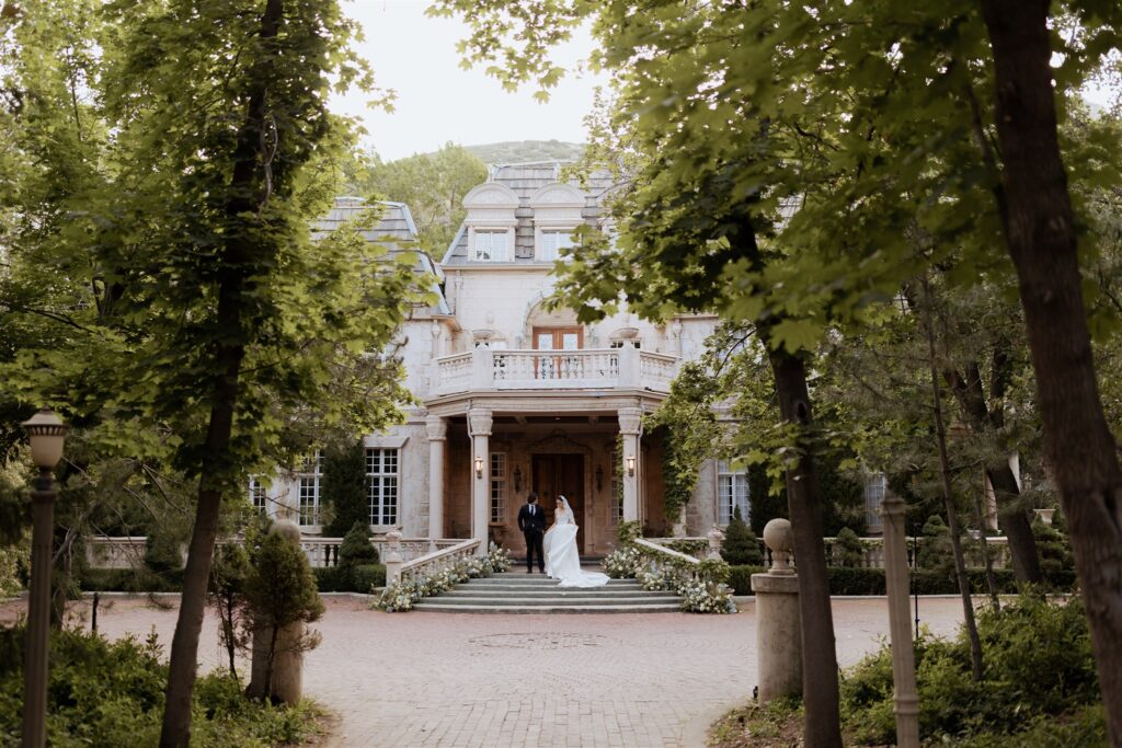 Bride and groom standing in front of La Caille wedding venue in Little Cottonwood Canyon Utah.