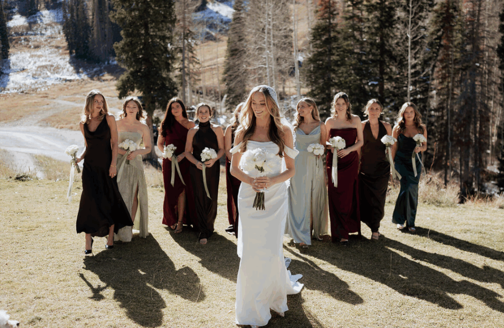 Bride walking with her bridesmaids, all holding bouquets during a Utah wedding.