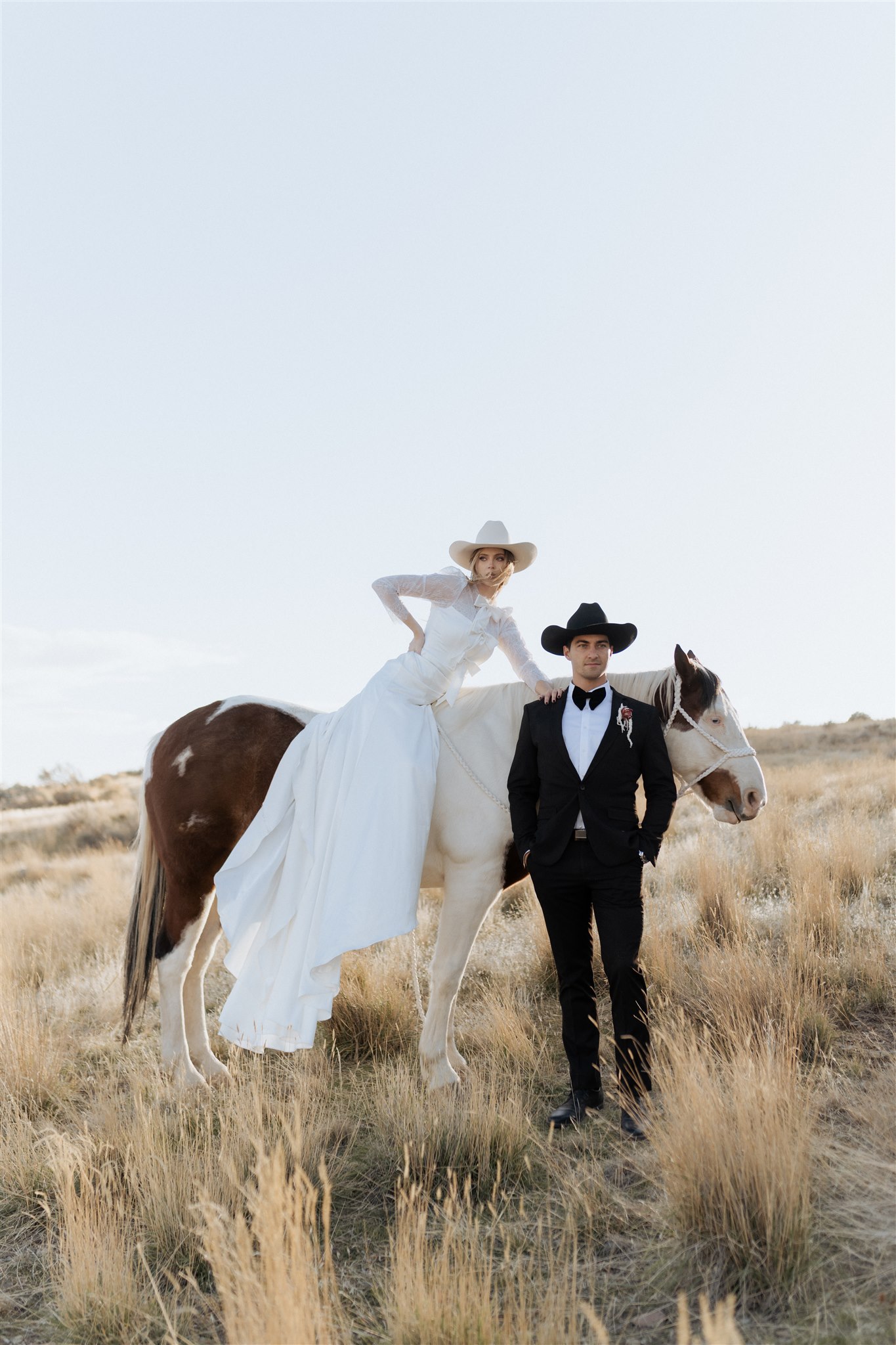 Western editorial bridal portrait in golden grass field with horse