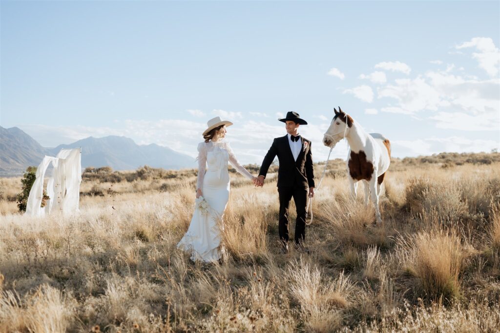 Bride and groom walking with horse during western elopement in Utah